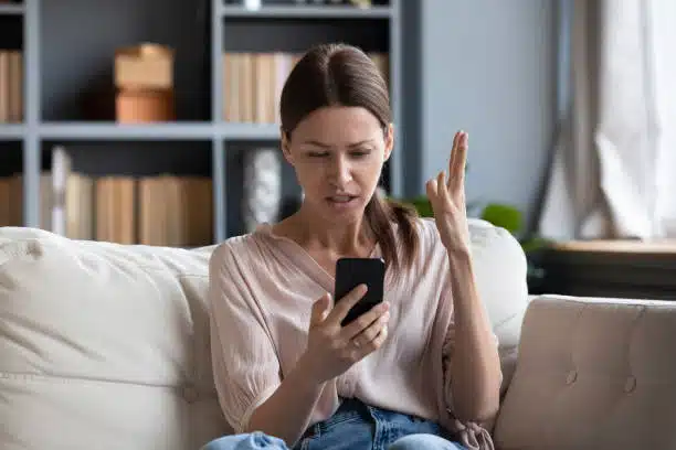 angry young woman having problem with phone